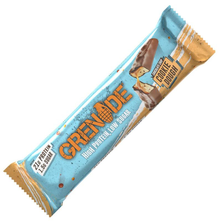 Grenade Proteinriegel Chocolate Chip Cookie Dough auf einem Tisch, in der Verpackung. Enthält 20g Protein und weniger als 2g Zucker pro Riegel. Ideal als proteinreicher, zuckerarmer Snack für zwischendurch oder nach dem Sport.