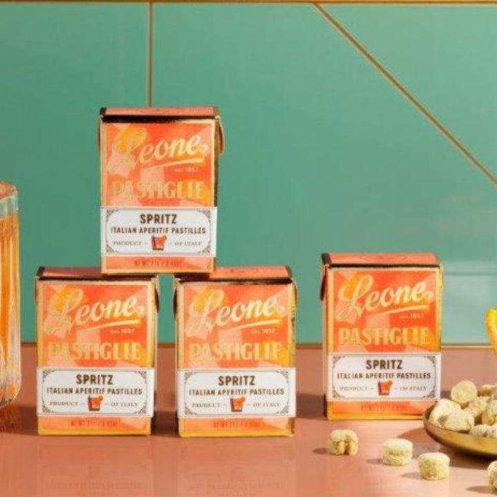 Zwei Verpackungen der Leone Spritz Pastillen stehen aufeinander gestapelt, daneben stehen zwei weitere Leone Spritz Pastillen Verpackungen.